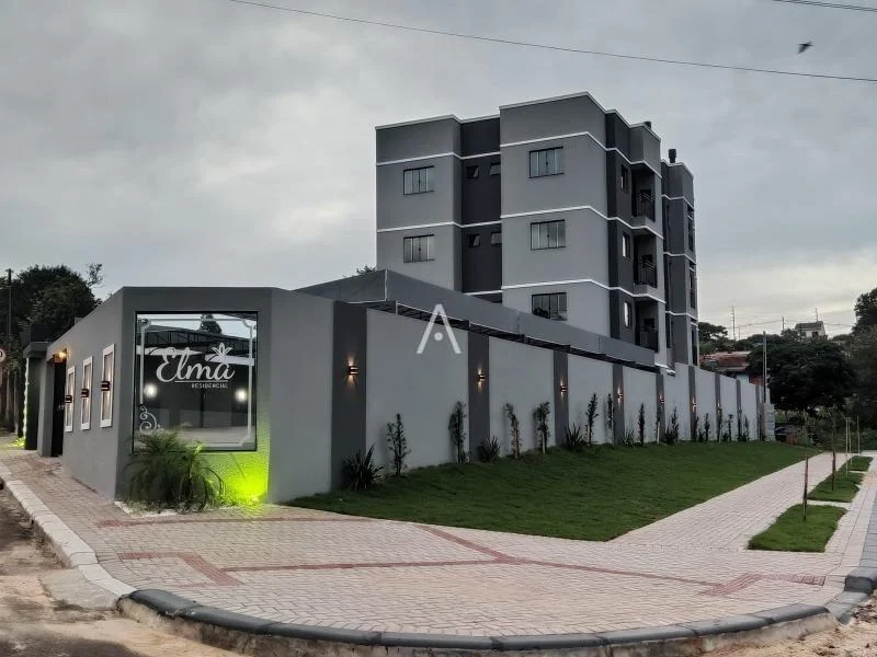 Fachada do Residencial Elma ao entardecer, com muro iluminado e paisagismo na esquina