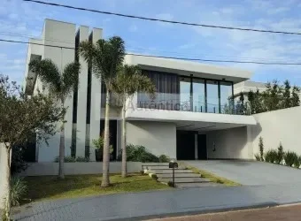 Fachada de sobrado alto padrão em condomínio, com varanda envidraçada e palmeiras