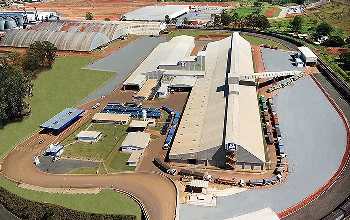 Vista aérea da unidade da Yara em Cascavel/PR, com galpão de estocagem e carretas em fila